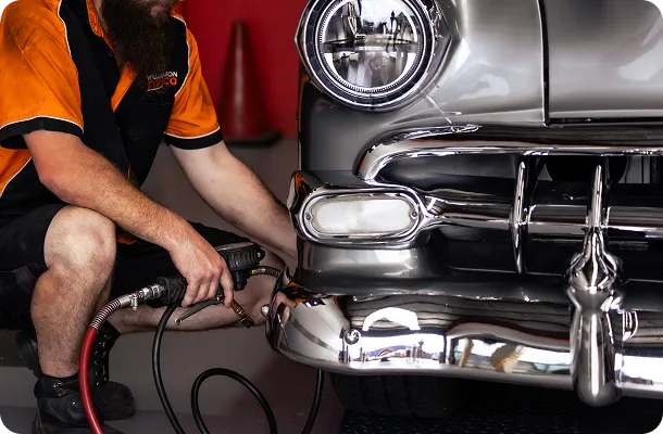 A Williamson Tyreco technician inflating the tyre of a classic chrome car